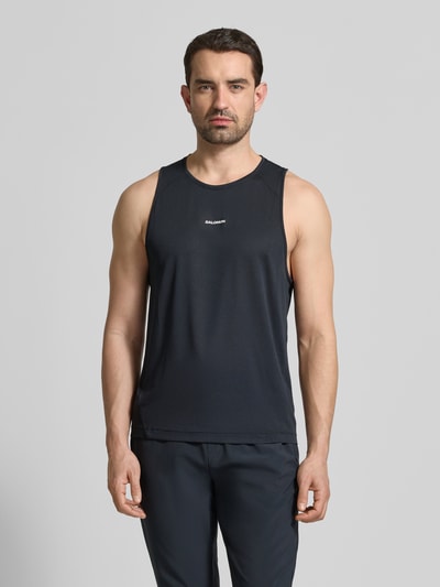 Männermodel trägt Tanktop mit Rundhalsausschnitt Modell 'SHKOUT CORE' von Salomon in Schwarz, Mesh, körpernahe Passform, Ganzkörperansicht von vorne.