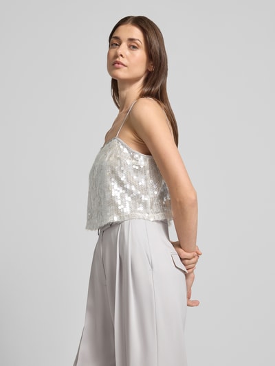 Frauenmodel trägt Cropped Trägertop mit Pailettenbesatz - curated by Vicky Heiler von SIC, silbern glänzend, Spaghettiträger, Ganzkörperansicht von vorne.