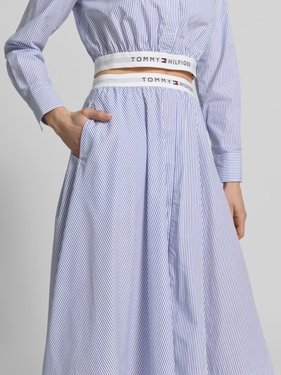 Kobiece modelka nosi Ausgestellter Midi-Rock aus reiner Baumwolle von Tommy Hilfiger, wzór w paski, krój regular fit, rozkloszowana, długość midi, z napisem z logo, elastyczny pas, wykończenie materiału: tkana faktura, materiał: bawełna; zbliżenie na górną część ciała