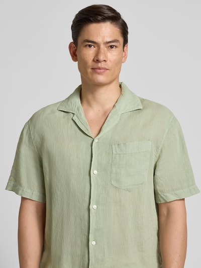 Männermodel trägt Regular Fit Freizeithemd aus reinem Leinen Modell 'EXOLINO' von HUGO in hellem Grün, einfarbig, Nahaufnahme Oberkörper.