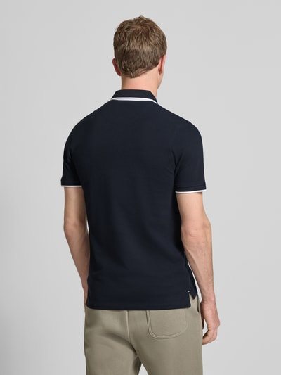 Männermodel trägt Slim Fit Poloshirt mit Viskose-Anteil Modell 'Paulos' von JACK & JONES in Dunkelblau, Baumwoll-Mix, Rückenlänge 72 cm, Ganzkörperansicht Rückansicht.