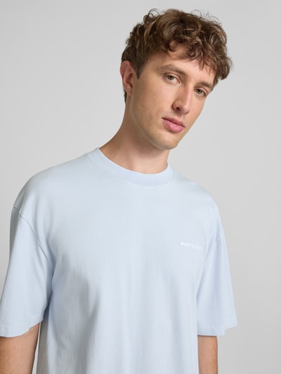 Männermodel trägt Oversized T-Shirt mit Label-Stitching von Pegador aus Baumwoll-Mix, Herren T-Shirt, Rundhalsausschnitt, Nahaufnahme Oberkörper. Rückenlänge 70 cm bei Größe M.