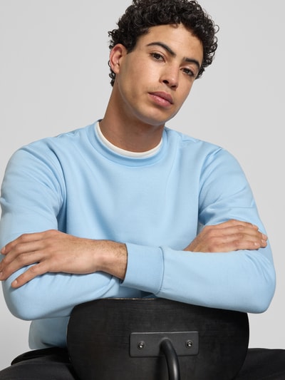 Männermodel trägt Regular Fit Sweatshirt aus Baumwoll-Mix Modell 'CERES' von Only & Sons in Hellblau, Rundhals, Nahaufnahme Oberkörper.