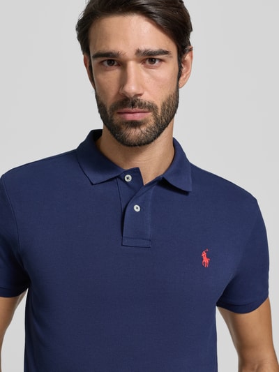Männermodel trägt Slim Fit Poloshirt mit Logo-Stitching von Polo Ralph Lauren aus reiner Baumwolle im unifarbenen Design, Nahaufnahme Oberkörper.