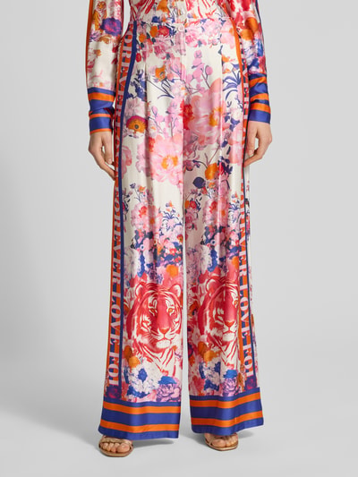 Frauenmodel trägt Wide Leg Hose aus Viskose Modell 'wild Flower' von miss goodlife mit Blüten- und Tigermuster in bunt, Ganzkörperansicht von vorne. Reine Viskose, Knopfverschluss, Teilungsnähte, weites Bein, Bundweite Größe S 35 cm, Innenbeinlänge 88 cm.