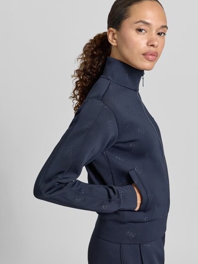 Frauenmodel trägt Sweatjacke mit Logo-Muster Modell 'CALISTA' von Guess Activewear in Dunkelblau, Material-Mix mit Stretch, Nahaufnahme Oberkörper