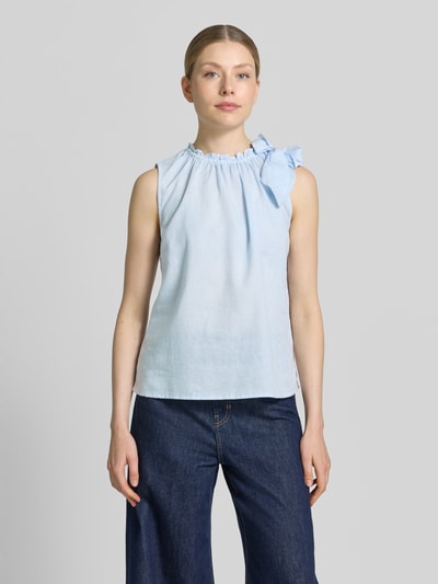 Frauenmodel trägt Regular Fit Bluse aus Viskose-Mix mit Leinen-Anteil von Christian Berg Woman in Hellblau, Zierschleife, Stehkragen mit Rüschenbesatz, Ärmelloses-Design, Rückenlänge 54 cm bei Größe 36, Ganzkörperansicht von vorne.