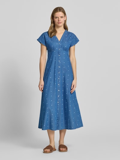 Modelka kobieca nosi tailliertes Jeanskleid aus reiner Baumwolle Modell 'NOVA AZURE' od Only w kolorze niebieskiego denimu z jasnym wzorem allover, midi, krótki rękaw, dekolt w serek, zapinana na guziki, materiał bawełna, widok całej sylwetki z przodu.