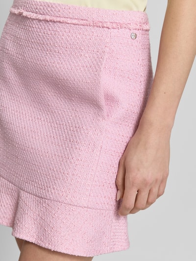 Frauenmodel trägt Minirock in Bouclé-Optik von Marc Cain, Baumwoll-Mix mit Viskose-Anteil, rosa, Nahaufnahme Oberkörper