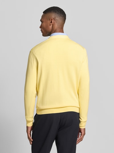 Männermodel trägt Regular Fit Strickjacke aus reiner Baumwolle von Polo Ralph Lauren, look: effen, materaalverwerking: knitwear, pasvorm: regular fit, sluiting: knoopsluiting, logodetail, crew neck, diepe v-hals, lange mouw, mouwboord en rompzoom geribd, opgestikte zijzak, kleur zachtgeel, puur katoen. Ganzkörperansicht Rückansicht.