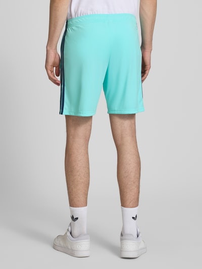 Männermodel trägt Auswärtsshorts Deutschland 2026 von adidas Sportswear, mehrfarbig, Regular Fit mit Tunnelzugbund, Ganzkörperansicht Rückansicht.