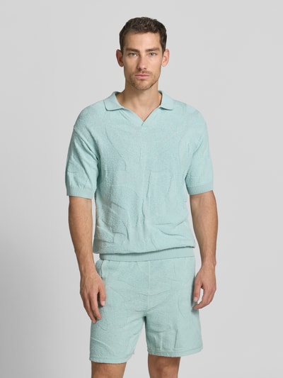 Männermodel trägt Relaxed Fit Poloshirt aus reiner Baumwolle Modell 'ASURFO' von BOSS Orange, Optik: Unifarben, Struktur, Ganzkörperansicht von vorne.