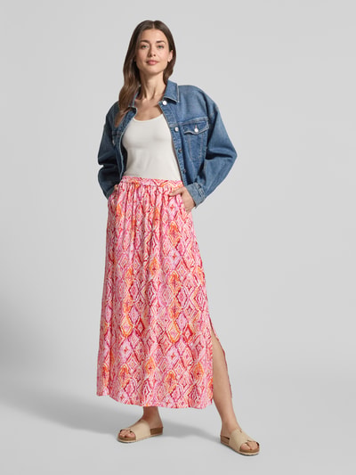 Vrouwenmodel draagt Ausgestellter Maxi-Rock aus reiner Viskose Modell 'EASY JOY' van Vero Moda met all-over grafisch motief, maxilengte, uitlopend, elastische boord, popeline van zuiver viscose, kleurrijke tinten, ganzlichaamsaanzicht van voren.
