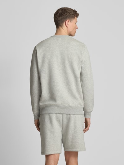 Mannelijk model draagt sweatshirt met logo en ronde hals van GAP, katoenmix, regular fit, ruglengte maat M 69 cm, mouwlengte 65 cm. Ganzlichaamsaanzicht achteraan.