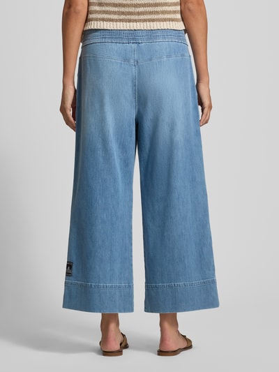 Frauenmodel trägt Jeans in verkürzter Passform mit elastischem Bund von Marc Cain aus Baumwoll-Mix, Wide Leg, hellblau, Ganzkörperansicht Rückansicht.