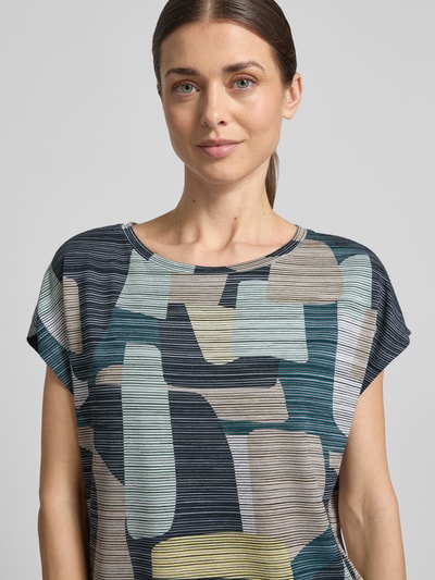 Vrouwenmodel draagt Oversized Bluse aus Viskose-Mix van Tom Tailor, camouflage allover, meerkleurig, crew neck, stretch, Nahaufnahme bovenlichaam.