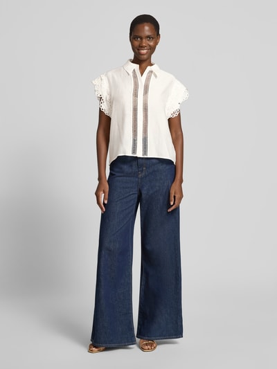 Frauenmodel trägt Blusentop aus Lyocell-Mix mit Spitze Modell 'MOLLY' von Copenhagen Muse in Weiß, kombiniert mit weiten Jeans, Regular Fit, Hemdblusenkragen, verdeckte Knopfleiste, Rückenlänge 62 cm, Ärmellänge 4 cm, Ganzkörperansicht von vorne.