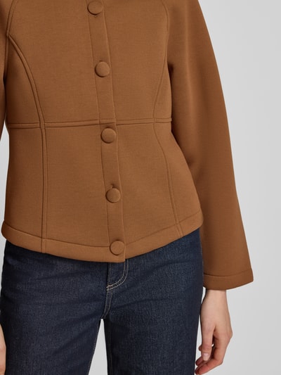 Frauenmodel trägt Jacke aus Viskose-Mix mit Rundhalsausschnitt von Rich & Royal in Braun, Knopfleiste, Regular-Fit, Nahaufnahme Oberkörper, Rückenlänge bei Größe S 53 cm, Schulterbreite 43 cm, Brustweite 46 cm, Ärmellänge 68 cm, glatte Textur.