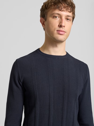Männermodel trägt Slim Fit Pullover in Strick-Optik Modell 'Baron' von Blend, reine Baumwolle, Rundhalsausschnitt, Nahaufnahme Oberkörper.