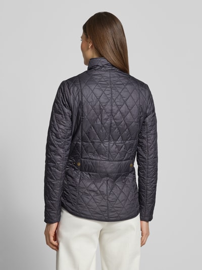 Frauenmodel trägt Regular Fit Steppjacke mit Stehkragen Modell 'FLYWEIGHT' von Barbour in unifarbener Optik, Ganzkörperansicht Rückansicht.