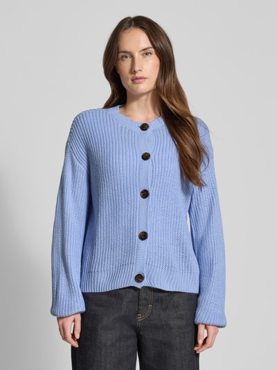 Vrouwenmodel draagt Regular Fit Strickjacke met eenreihige knoopsluiting Modell 'LEA' van Vero Moda in effen lichtblauw breisel, lange mouwen, geribde boorden, ronde hals, voorkant, close-up bovenlichaam.
