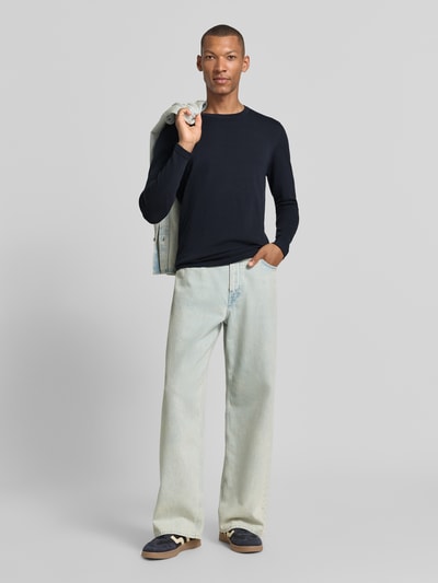Mannenmodel draagt Slim Fit Langarmshirt puur katoen van DRYKORN in zwart met ronde hals en ribboordjes, ruglengte 70 cm, mouwlengte 70 cm, vooraanzicht hele lichaam.
