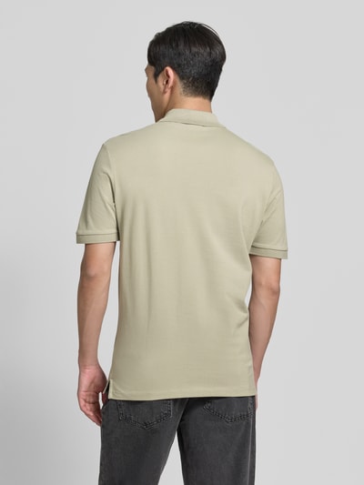 Männermodel trägt Regular Fit Poloshirt aus reiner Baumwolle Modell 'DONOS222' von HUGO in Beige, feine Webstruktur, Ganzkörperansicht Rückansicht.