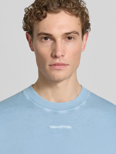 Männermodel trägt Relaxed Fit T-Shirt aus reiner Baumwolle von Marc O'Polo in Optik: Unifarben mit Label-Stitching-Applikation, Nahaufnahme Oberkörper.