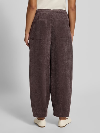 Frauenmodel trägt Barrel Jeans mit Tunnelzug Modell 'Misha barrel' von OPUS in dunklem Braun, lockere Passform, Damen Barrel Jeans, Ganzkörperansicht Rückansicht.