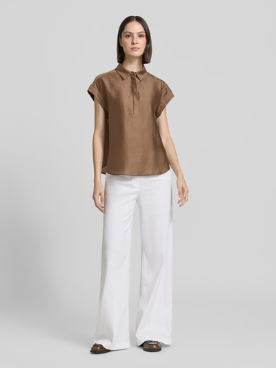 Frauenmodel trägt Regular Fit Bluse aus Lyocell-Mix Modell 'Zamin' von Someday in Braun, mit Hemdblusenkragen, verdeckter Knopfleiste und Kappärmel, Rückenlänge bei Größe 36: 62 cm, Ärmellänge: 12 cm, glatte Oberfläche, Ganzkörperansicht von vorne.