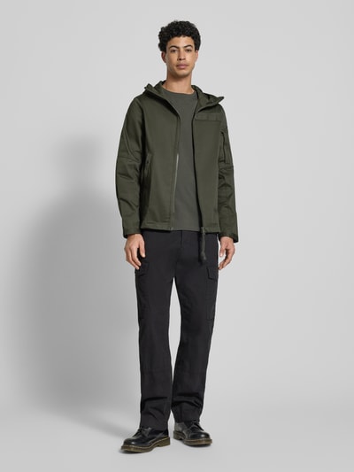 Mannenmodel draagt Regular Fit Regenjacke met rits Modell 'Batt' van G-Star Raw, olijfgroen, katoenmix, met capuchon, zakken, frontaal totaalbeeld.