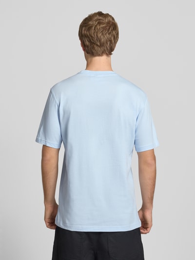 Männermodel trägt Regular Fit T-Shirt aus reiner Baumwolle von adidas Originals in Hellblau, unifarben, Rundhals, kurzarm, Jersey, Ganzkörperansicht Rückansicht.