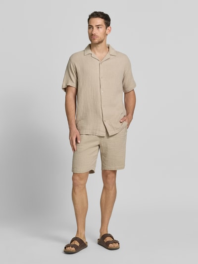 Männermodel trägt Relaxed Fit Freizeithemd mit Strukturmuster von Lindbergh aus Reiner Baumwolle, Beige mit Reverskragen, Ganzkörperansicht von vorne.