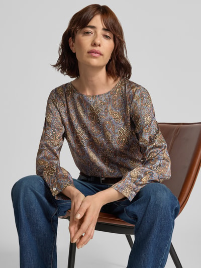 Frauenmodel trägt Blusenshirt aus Satin im Allover-Look Modell 'REGNO' von EMME, gemusterte Oberfläche in Blau-Braun, Nahaufnahme Oberkörper.