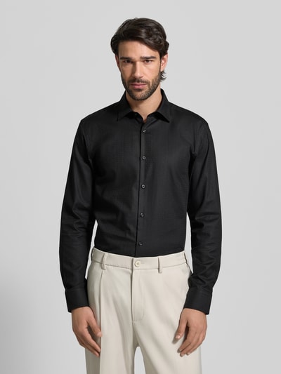 Männermodel trägt Slim Fit Freizeithemd aus reiner Baumwolle Modell 'KENNO' von HUGO in Schwarz mit feinem Strukturmuster, Ganzkörperansicht von vorne.