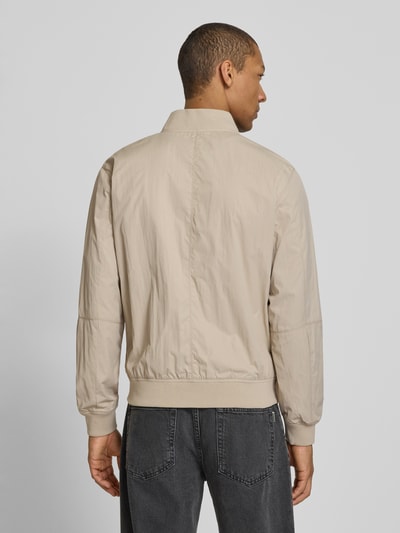 Męski model nosi Regular Fit Bomberjacke mit Stehkragen von s.Oliver RED LABEL, efekt: jednolity kolor, długi rękaw, kieszenie z patką, stójka, zamek błyskawiczny, prążkowane zakończenia, kieszeń wewnętrzna, Ganzkörperansicht Rückansicht.