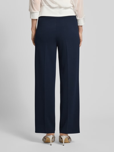 Frauenmodel trägt Stoffhose mit Bügelfalte und elastischem Bund von Vera Mont im Loose-Fit, Material-Mix mit Stretch-Anteil, Ganzkörperansicht Rückansicht.