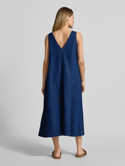Vrouwenmodel draagt Loose fit Jeanskleid aus Baumwoll-Lyocell-Mix van Armedangels in denimlook, midilengte, brede bandjes, met steekzakken, twillstructuur, kleur donkerblauw. Ganzkörperansicht Rückansicht.