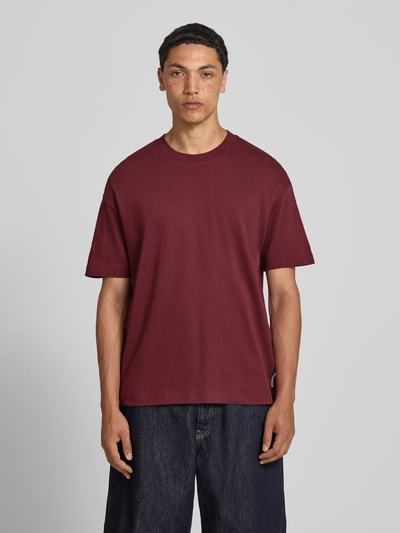 Männermodel trägt Relaxed Fit T-Shirt aus reiner Baumwolle von Marc O'Polo Denim in Dunkelrot, schlichte Optik, Ganzkörperansicht von vorne. Herren T-Shirt.