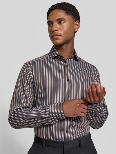 Mężczyznę model prezentuje Modern Fit Businesshemd aus reiner Baumwolle von OLYMP, brązowe i białe pionowe paski, koszula biznesowa, Ganzkörperansicht von vorne.