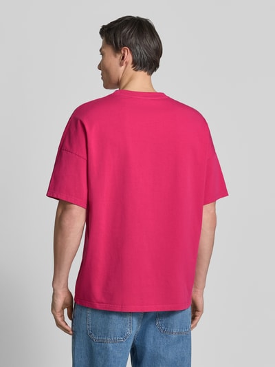 Männermodel trägt Herren T-Shirt mit geripptem Rundhalsausschnitt Modell 'FIZVALLEY' von American Vintage in Pink, Reine Baumwolle, Loose-Fit, Rückenlänge bei Größe M/L: 72 cm, Ganzkörperansicht Rückansicht.