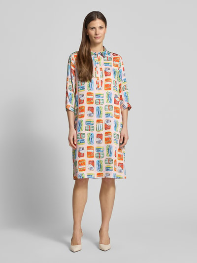 Frauenmodel trägt knielanges Hemdblusenkleid aus Viskose im Allover-Look von Milano Italy mit buntem, rechteckigem Muster, geradem Schnitt, Hemdblusenkragen und 3/4-Arm, Ganzkörperansicht von vorne.