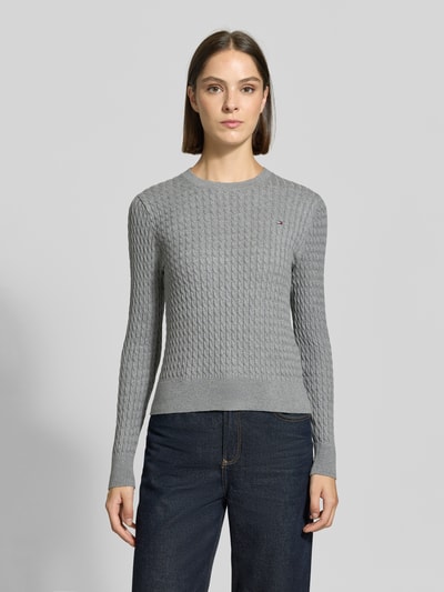 Frauenmodel trägt Regular Fit Pullover aus reiner Baumwolle von Tommy Hilfiger in Hellgrau, strukturierte Oberfläche, Ganzkörperansicht von vorne, Damen Pullover von Tommy Hilfiger.