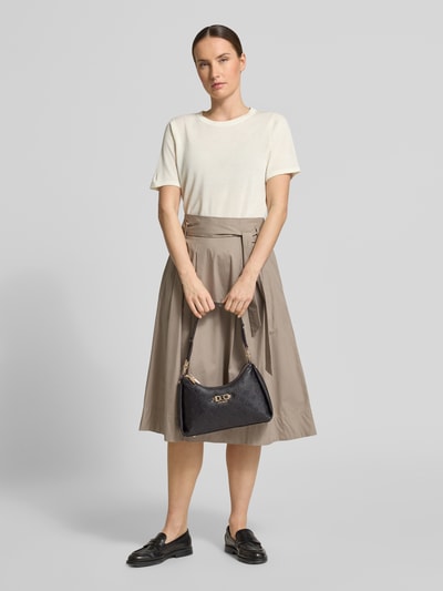 Kobiece modelka nosi Shoulder Bag in Leder-Optik mit Logo-Detail Modell 'Anise' od Guess, czarny materiał skóropodobny, detal z logo, pasek na ramię, główna przegroda z zamkiem błyskawicznym, szerokość w rozmiarze 1: 30 cm, długość w rozmiarze 1: 19 cm, głębokość w rozmiarze 1: 8 cm, długość paska na ramię w rozmiarze 1: 52 cm, widok całej sylwetki z przodu.