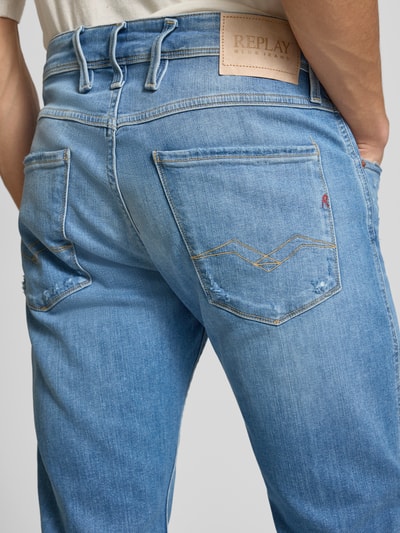 Mężczyznamodel nosi Slim Fit Jeans im Used Look Modell 'Anbass' od Replay, niebieski odcień, 5 kieszeni, detal z tyłu, materiał bawełniany z domieszką elastanu, krój slim fit, szerokość w rozmiarze 32/32: 46 cm, długość nogawki od wewnątrz: 82 cm, detaliczne ujęcie z tyłu.