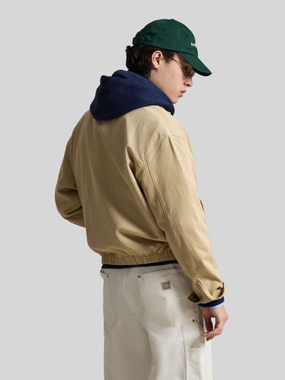 Männermodel trägt Regular Fit Blouson aus reiner Baumwolle von Polo Ralph Lauren in Beige, Twill-Struktur, Rückansicht Ganzkörperansicht.