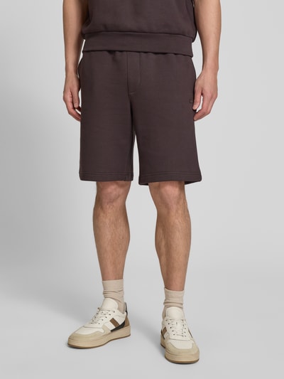 Männermodel trägt Relaxed Fit Sweatshorts aus reiner Baumwolle von Lacoste, Optik: Unifarben, Materialverarbeitung: Sweat, Logo-Detail, Tunnelzug, Bundabschluss: Elastisch, seitliche Eingrifftaschen, Gesäßtaschen, Ganzkörperansicht von vorne.