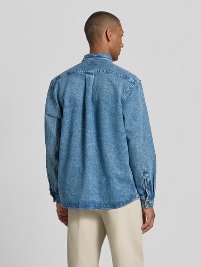 Männermodel trägt Regular Fit Jeansjacke aus reiner Baumwolle Modell 'LAMBEY BO FLEAK' von BOSS Orange, Denim-Optik, Ganzkörperansicht Rückansicht.