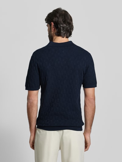 Männermodel trägt Regular Fit Poloshirt mit Strukturmuster von MCNEAL in Dunkelblau, reine Baumwolle, Strick-Optik, Ganzkörperansicht Rückansicht.