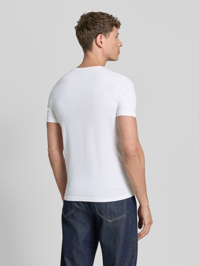 Männermodel trägt T-Shirt mit Rundhalsausschnitt Modell 'Alerio' von JOOP! Collection, weiß, reine Baumwolle, Regular Fit, Rückenansicht Ganzkörperansicht.